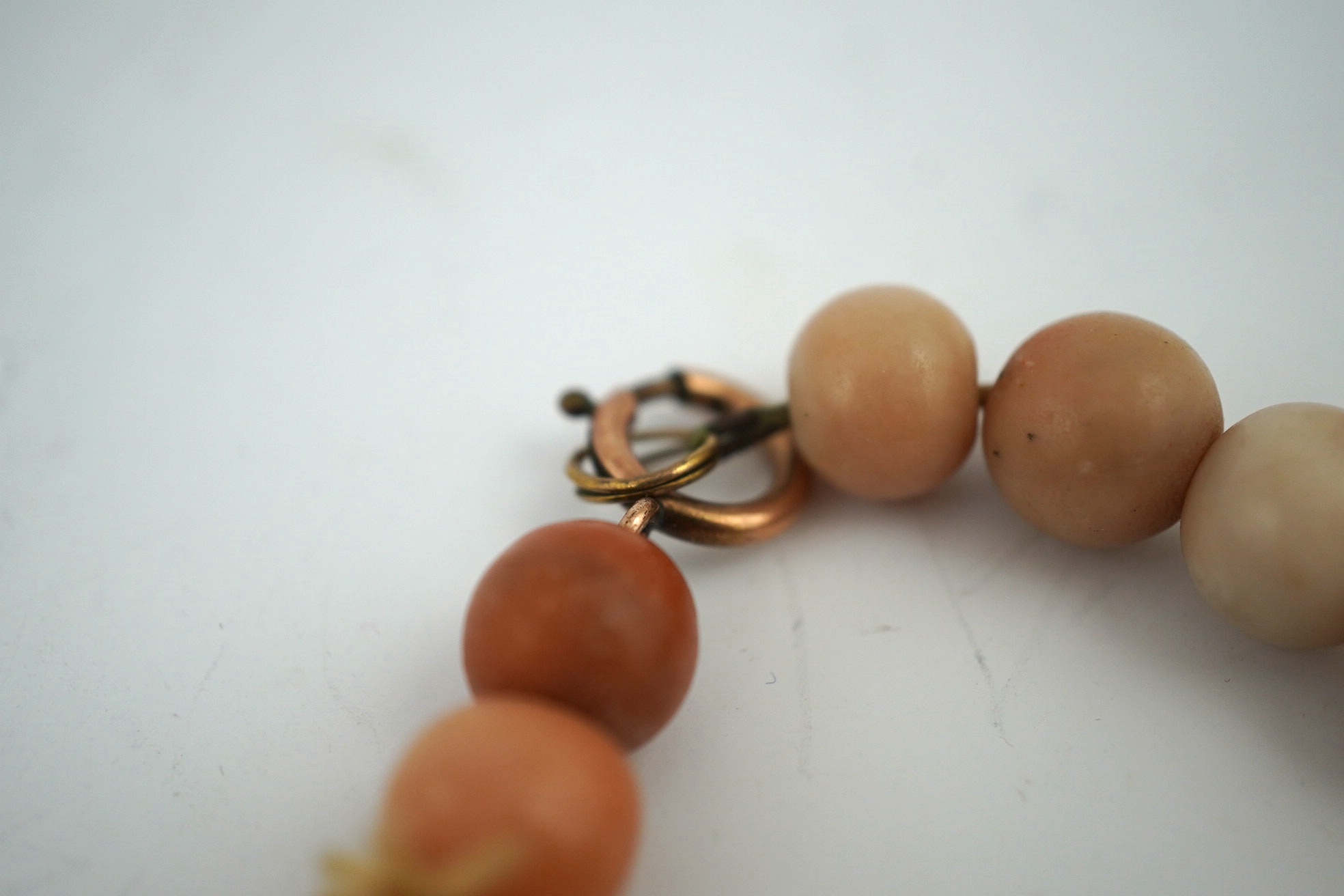 A Chinese coral bead rosary, 58cm drop and a pink soapstone bead necklace, 19.5cm. Condition - fair